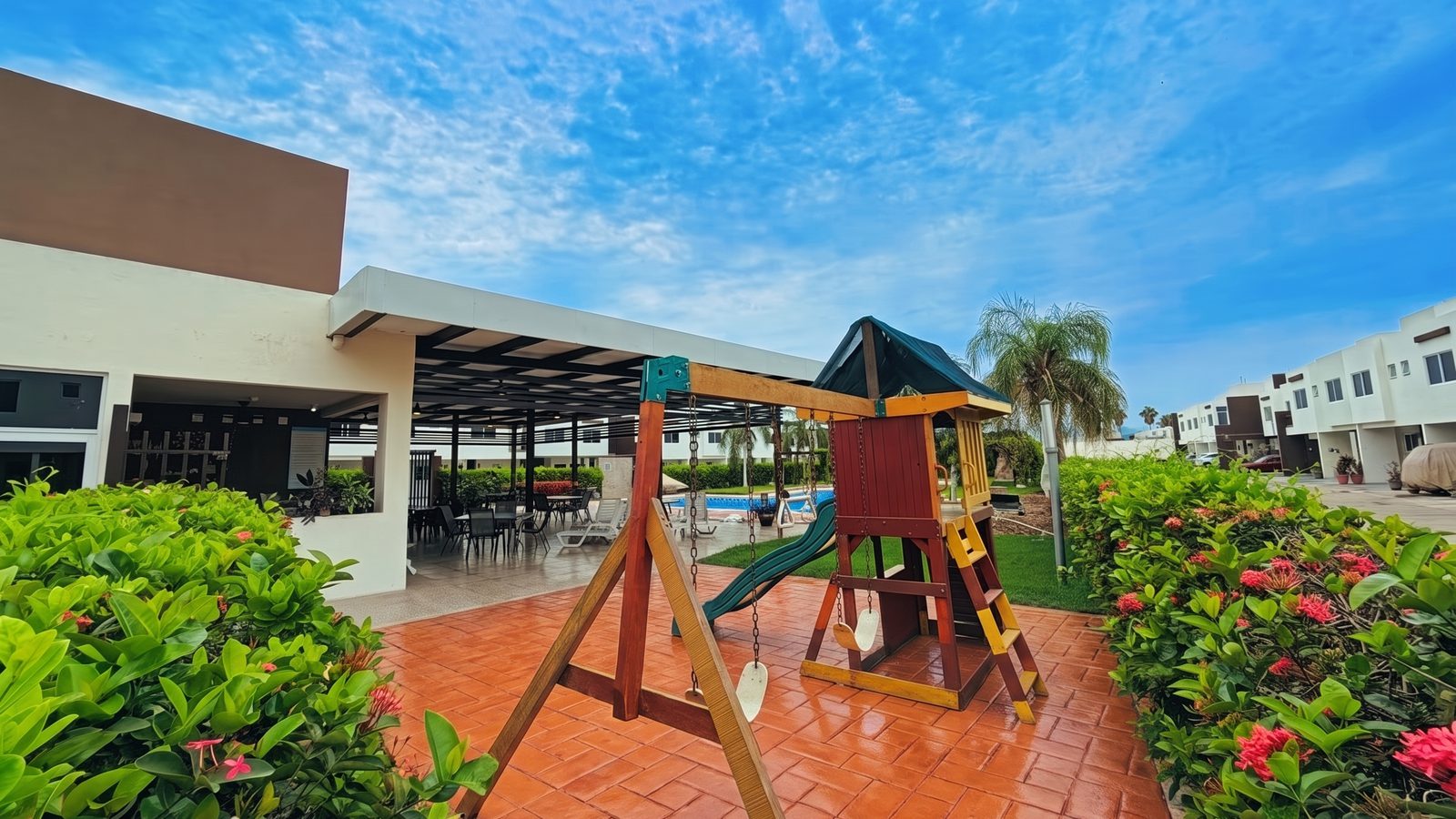 Casa club de Natura Residencial con terraza techada, juegos infantiles y alberca al fondo