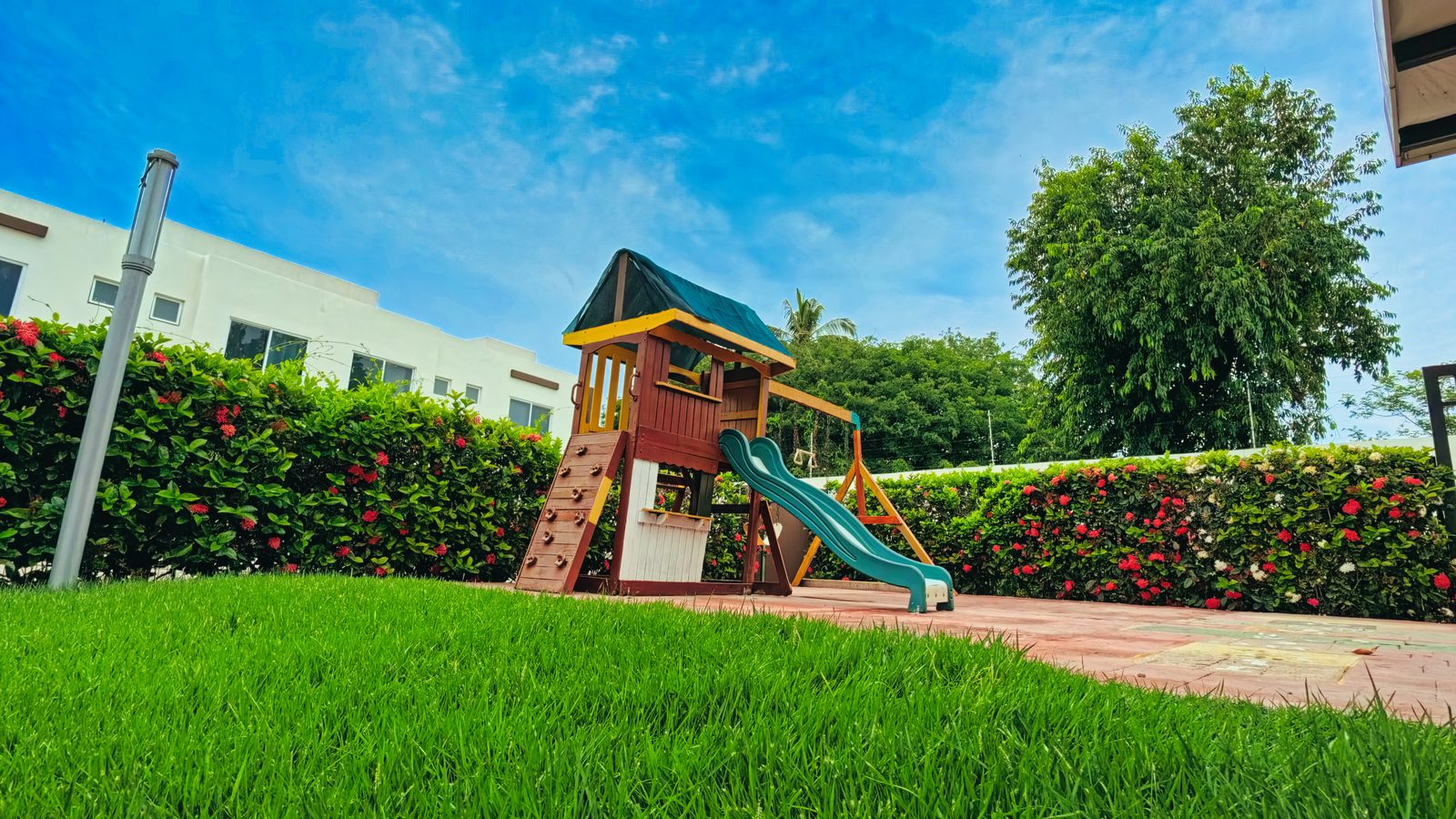 Área de juegos infantiles rodeada de jardines